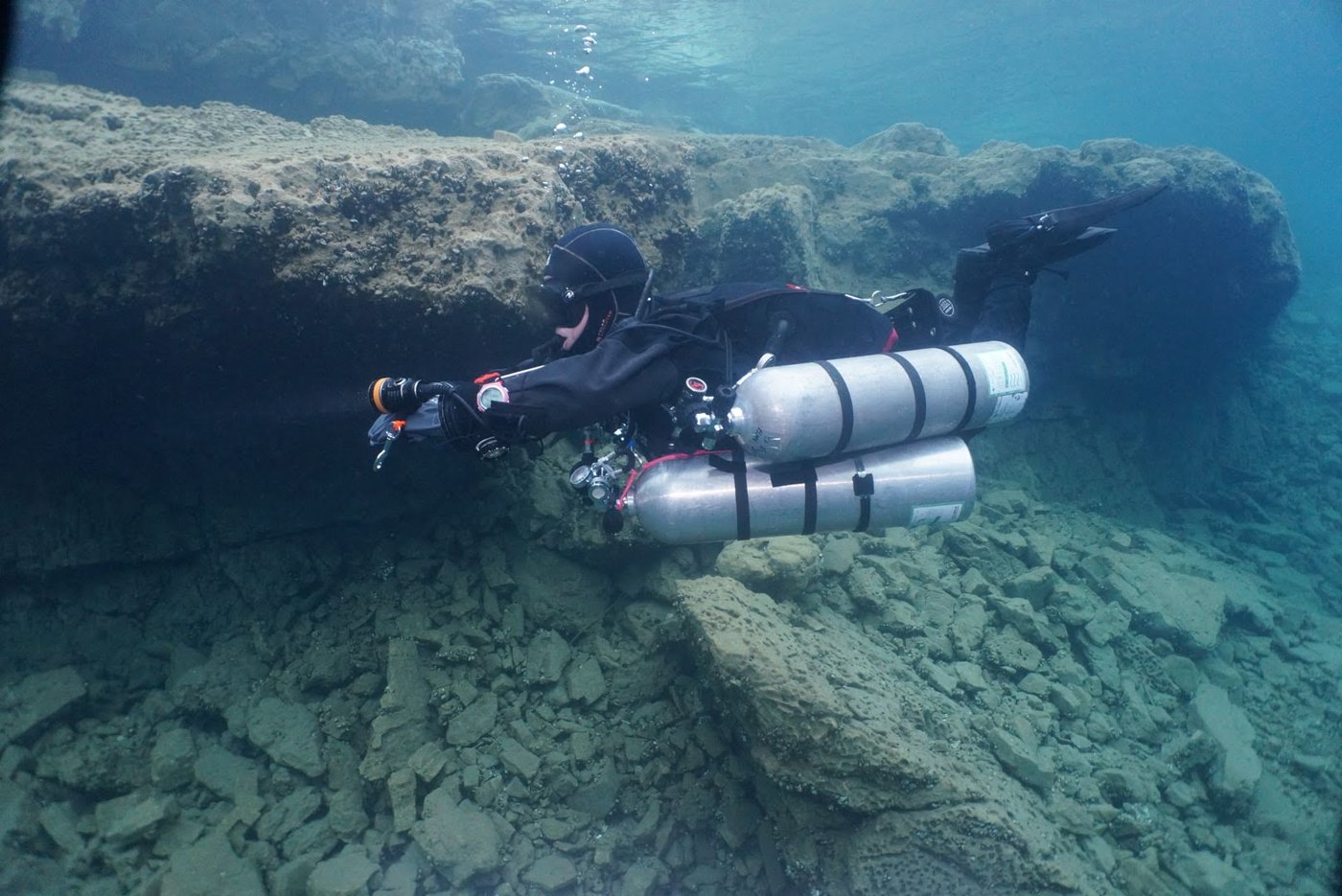 A sidemount diver exploring a shallow cave passage in Mexico.